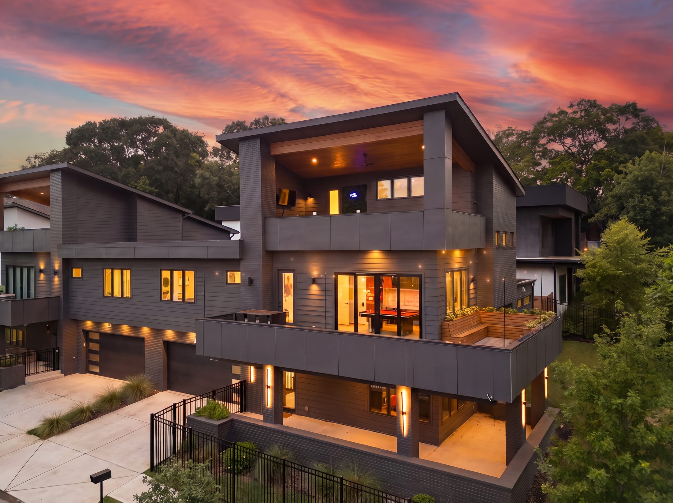 Modern luxury Atlanta residence at sunset with warm interior lighting and rooftop terrace