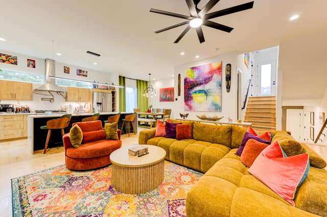 Open great room with sectional seating flowing into the kitchen and dining area