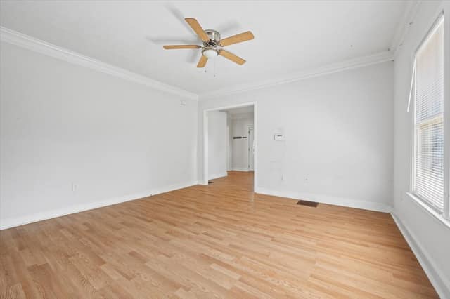 Separate dining room with hardwood flooring, crown molding, and ceiling fan