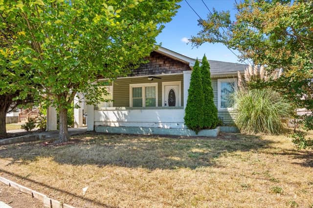 Front exterior of the 1926 bungalow at 3101 E Point St with covered porch and mature shade trees