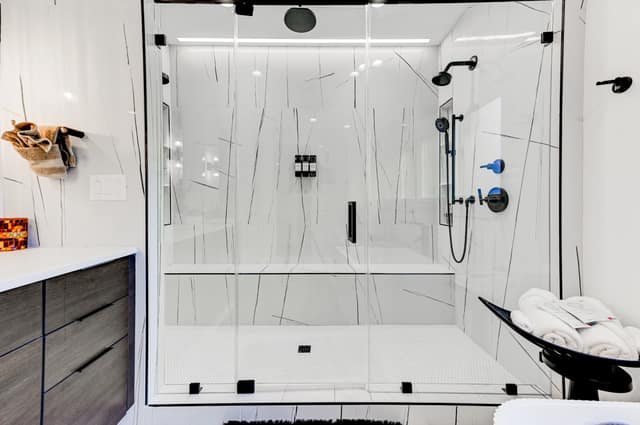 Frameless walk-in shower with rain and handheld shower heads
